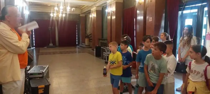 Деца слушат екскурзовод в украсеното фоайе на Русенската опера.