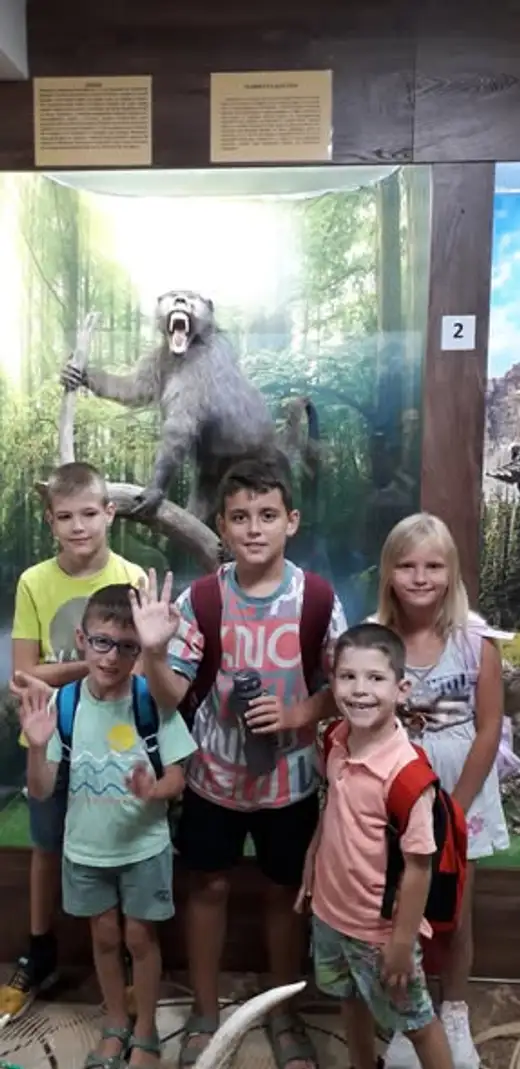Деца махат с ръце пред диорама с препарирана мечка