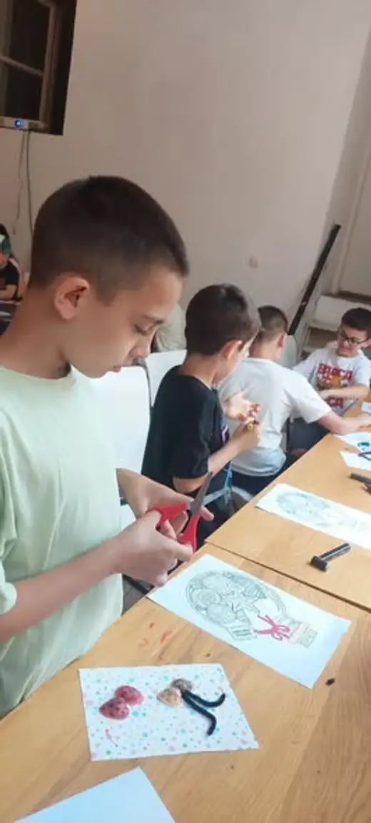 Момчета оцветяват морски картини на дървената маса