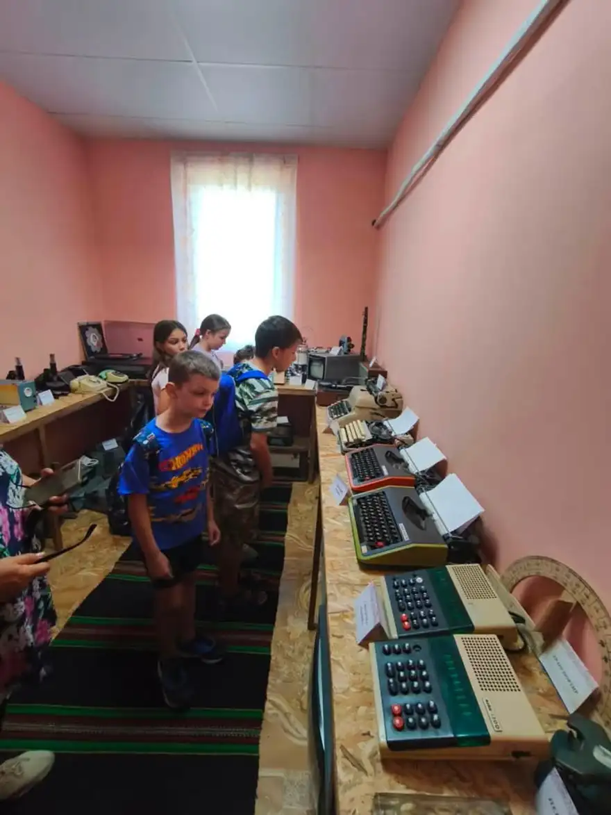 Деца разглеждат стая с пишещи машини и стари компютри в етнографския музей.