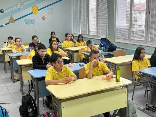 Ученици се събират в група пред телефон на статив.