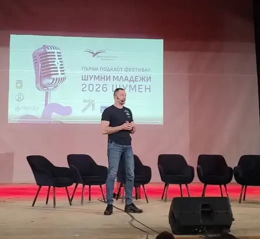 Мъж говори на сцената пред екран с надпис „Първи подкаст фестивал Шумни младежи 2026 Шумен“.