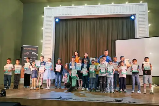 Деца със сертификати в ръце са наредени на сцената.